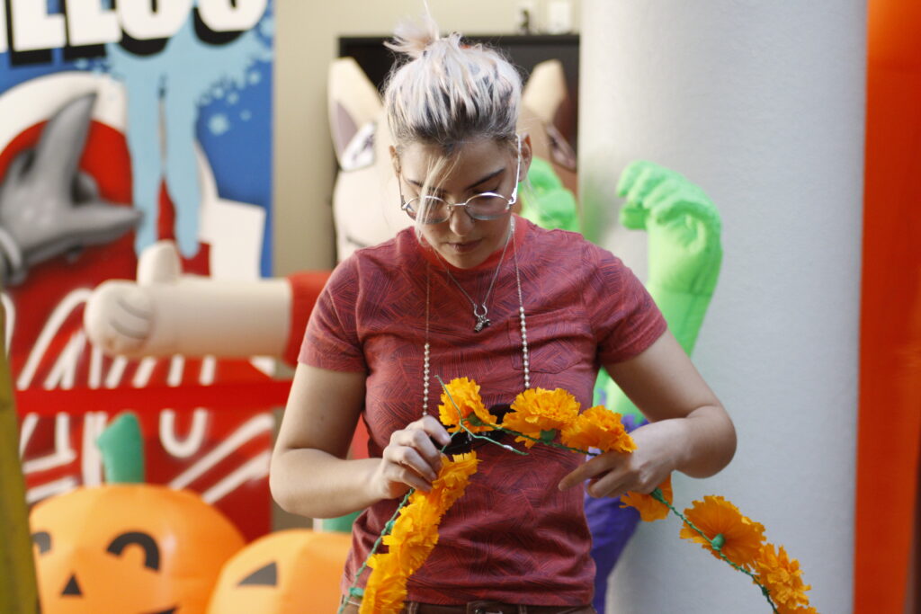 Nadia Guidry, a freshman liberal arts student, helps build SAC’s Dia De Los Muertos ofrenda in the Loftin Student Center atrium Oct. 9. Guidry and her sister Mia Guidry grew up making ofrendas with their mother every year for the Mexican holiday. Photo by Natalia Edwards.