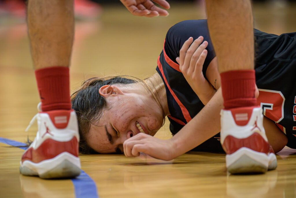 SAC’s Casie Guy struggles to get back up after a hard fall. Photo by A. De Leon.