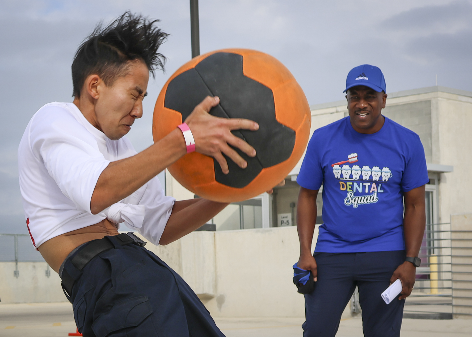 A competitor throws a medicine ball over his head in the “Reverse Cannonball” portion of the Backyard Beast Team Fitness Challenge at Parking Garage 3 Nov. 1. Photo by Lana Patterson.