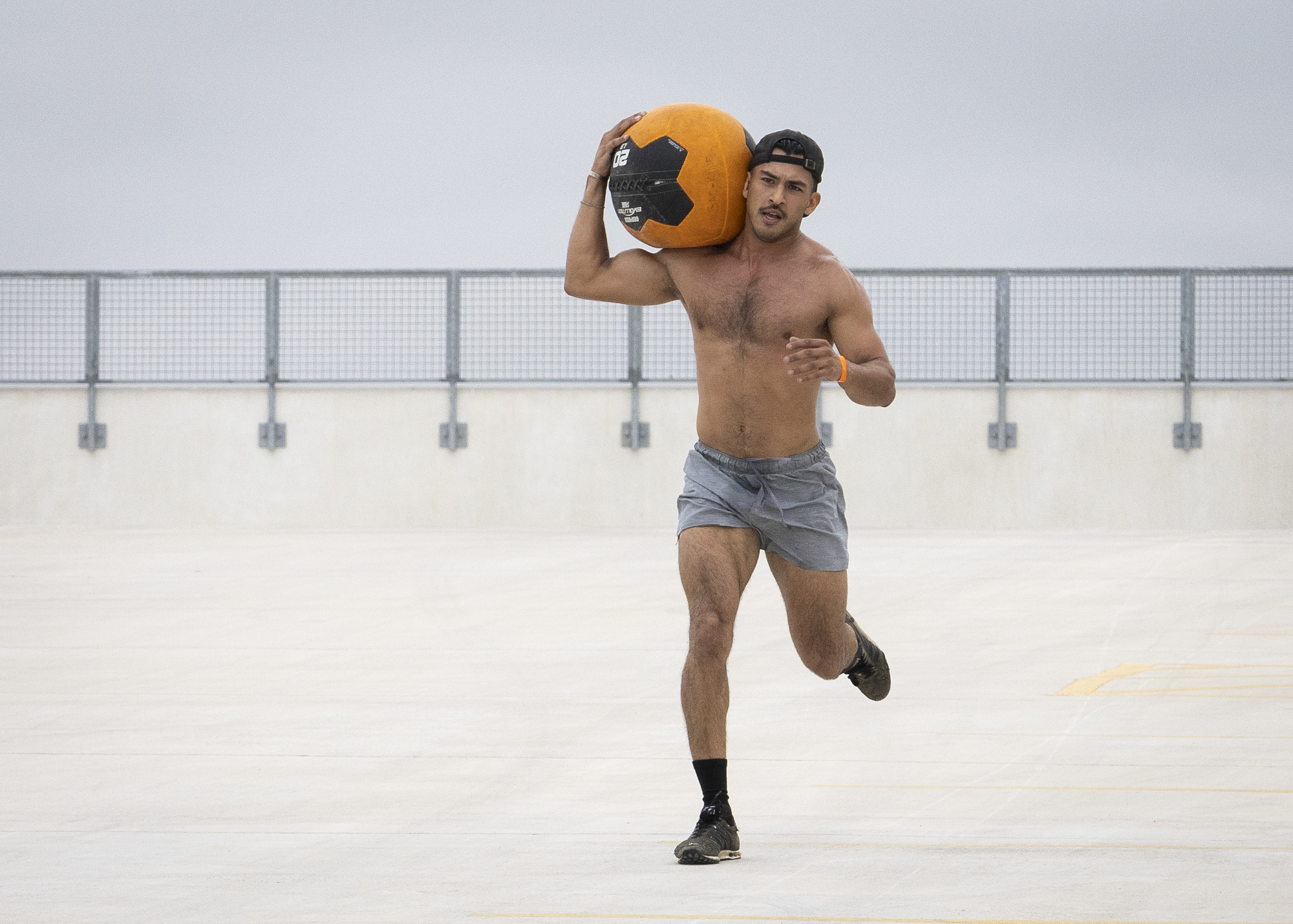 Carlos Cardenas of team OTF runs with a medicine ball after completing the “Reverse Cannonball” event of the Backyard Beast Team Fitness Challenge at Parking Garage 3 Nov. 1. Photo by Pablo Viveros.