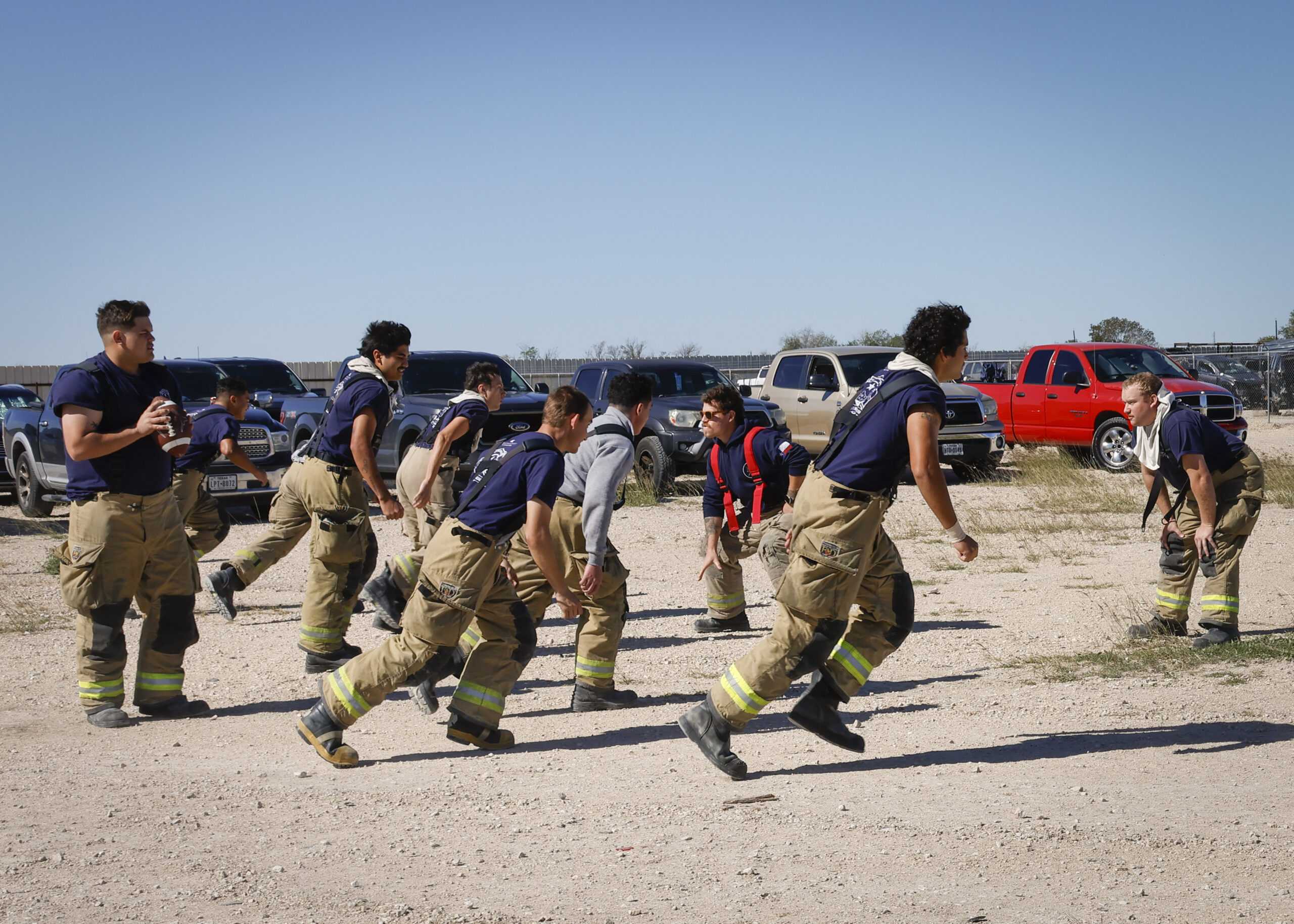 Fire Academy cadets play football while waiting for their lesson on vehicle extraction to begin. Photo by Natalia Edwards.