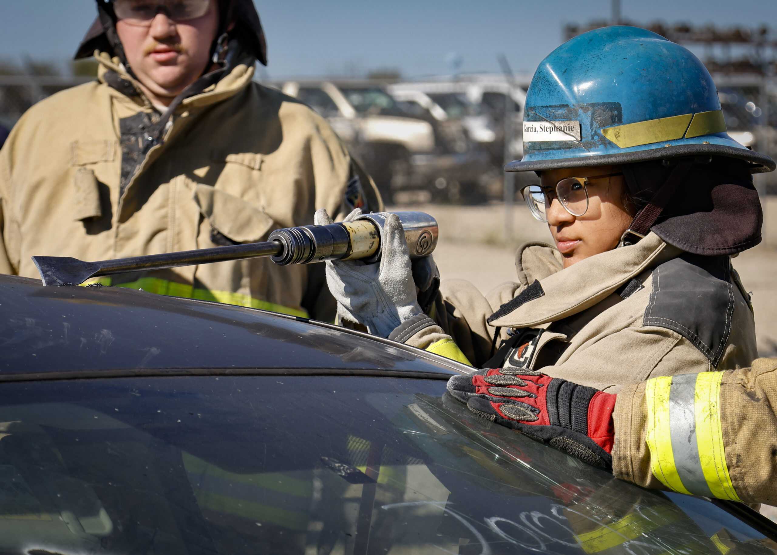 SAC Fire Academy Cadet Stephanie Garcia uses an air chisel to cut open the roof of a car while training on vehicle extraction. Photo by Natalia Edwards.