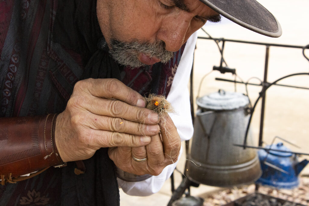 Living historian Rodney Cromeans demonstrates classic fire starting using flint, steel, and char cloth to spark a pinch of tinder for a family at the San Antonio Stock Show & Rodeo Feb. 12. Photo by Cesar A Pacheco.