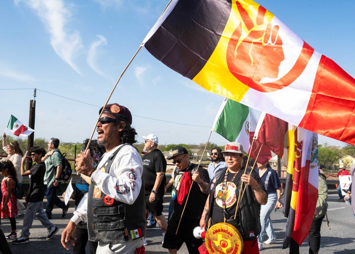 Member of The Brown Berets Juan Aguirre waves a flag at the 2025 César E. Chávez March for Justice. Photo by Jacob Lopez.