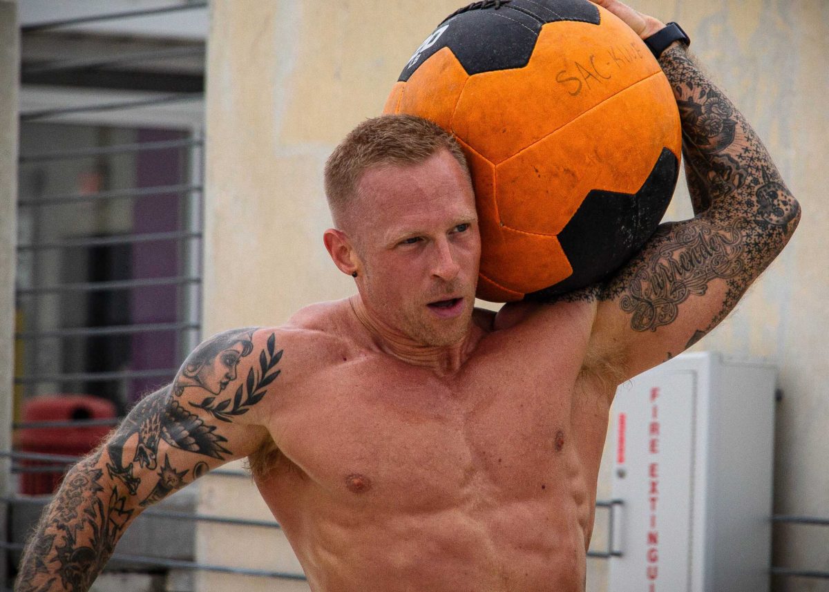 SAC Professor Dan Herrick carries a medicine ball at the Backyard Beast competition April 4. Photo by Jacob A. Esquivel.