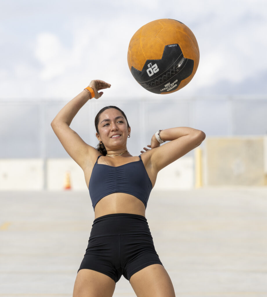 SAC Sophomore Sofia Prieto, a Kinesiology major and member of the “4L Gang” coed team, throws a medicine ball over her head in the Backyard Beast competition Oct. 24. Photo by Chris Hernandez.
