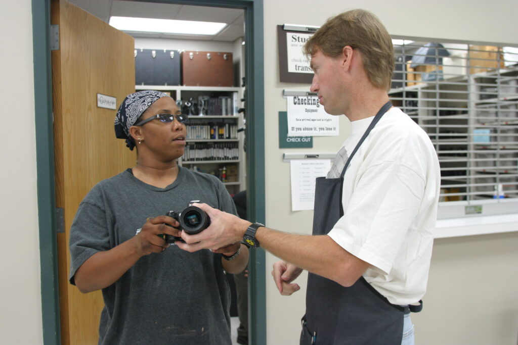 Photography Academic Lab Technician Mark Magavern advises a student on camera settings in SAC’s photography lab. Archive photo.