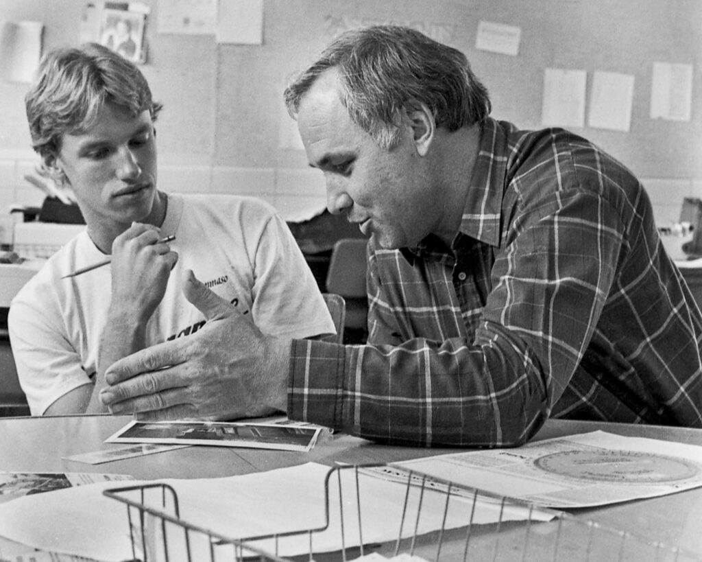 Ranger Advisor Jerry Townsend explains to journalism student Mark Magavern how to use a proportion wheel, the plastic disc newspaper editors used to determine the size an image needed to be when it ran in the newspaper. Archive photo.