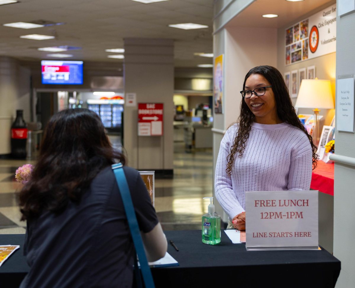 Theresa Noblitt, an Accounting and Business Administration major at SAC speaking with a SAC student about the Hunger Banquet event at San Antonio College on Feb. 17. Photo by Jose Ramirez