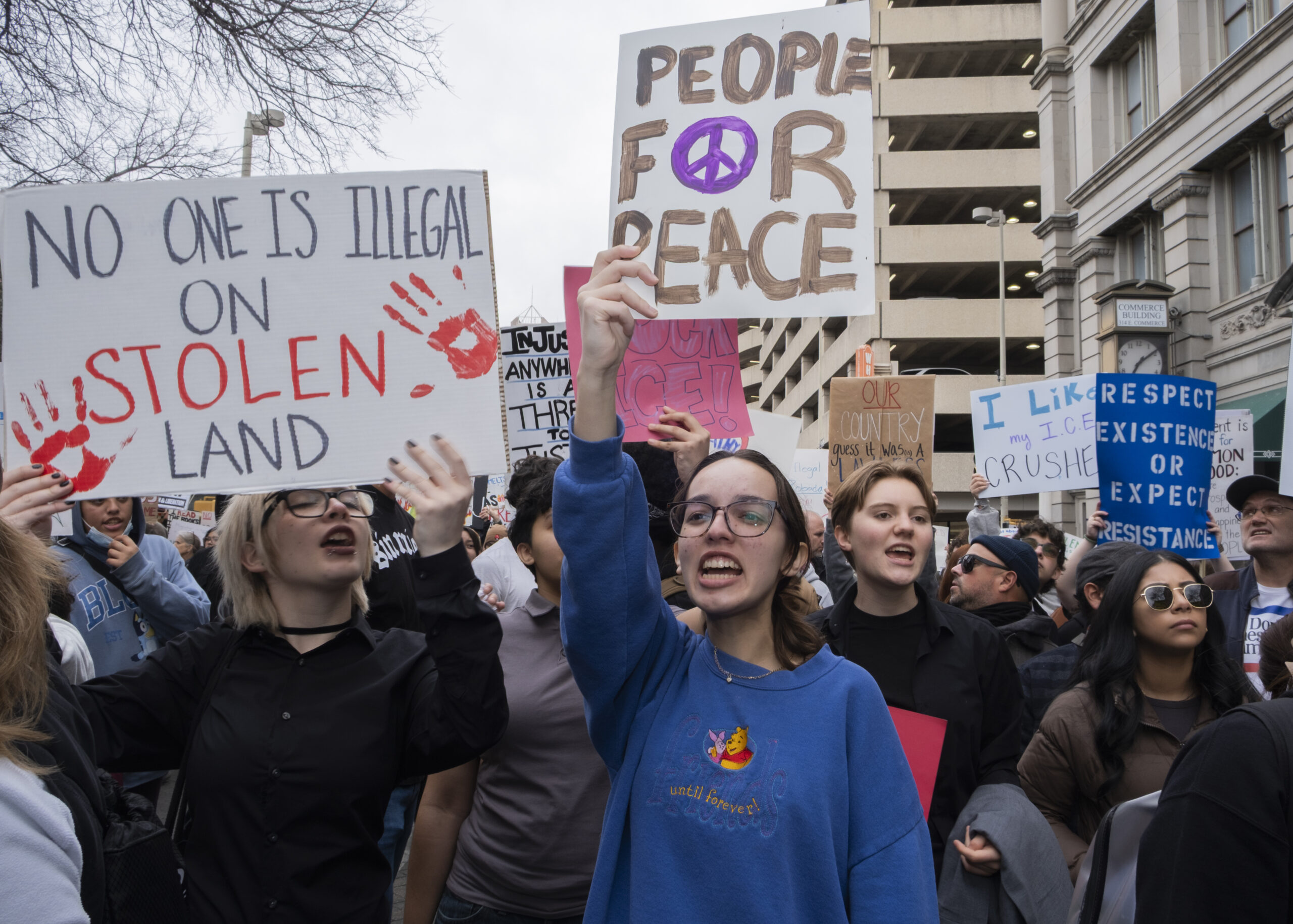 A protester marches down W Market as hundreds gathered in protest against recent fatal shootings involving federal agents in Minneapolis. Photo by Jacob R. Lopez.