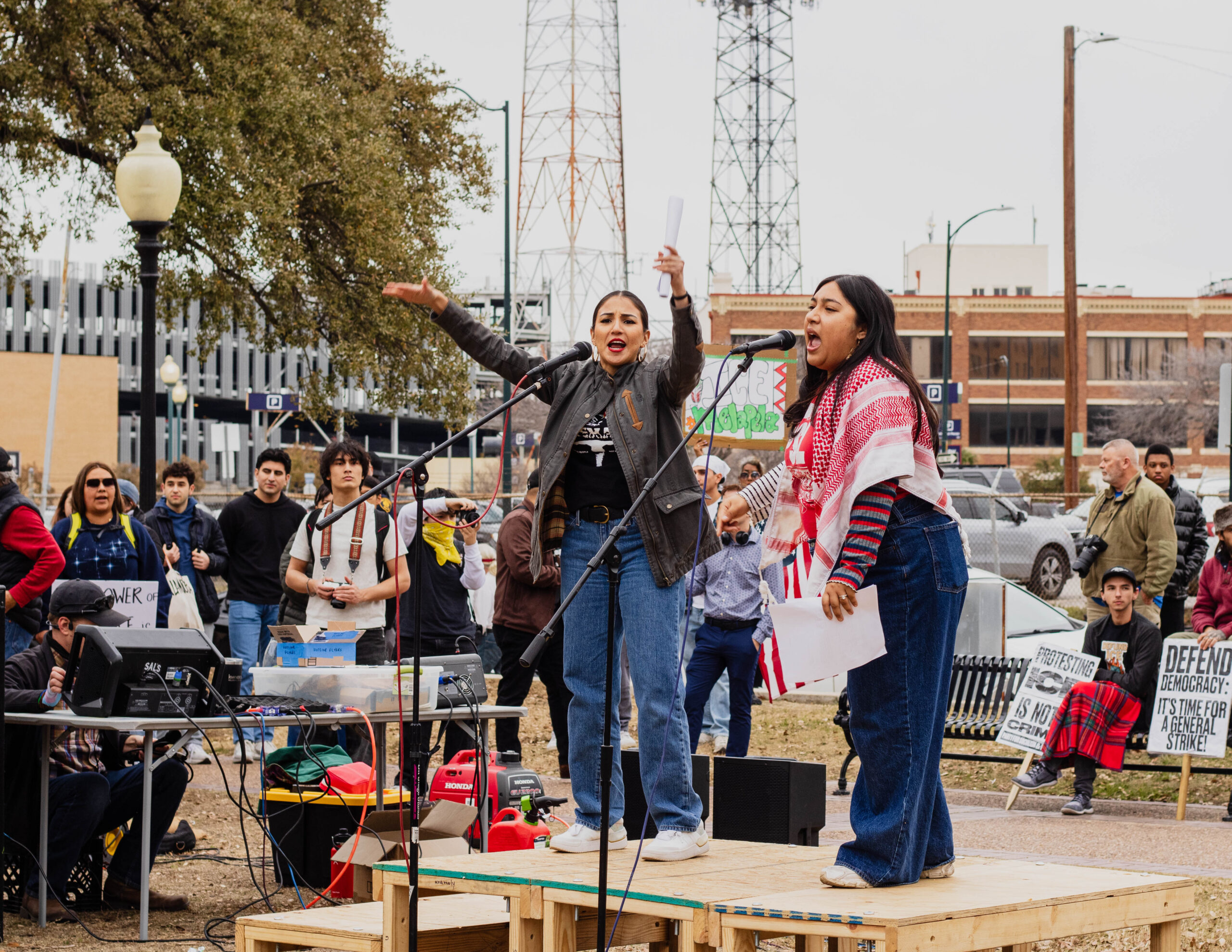 Jess Solis (left) and Tori Ramirez (right) stand on a podium and lead protest chants to the crowd. Photo by Hailey Vilegas.