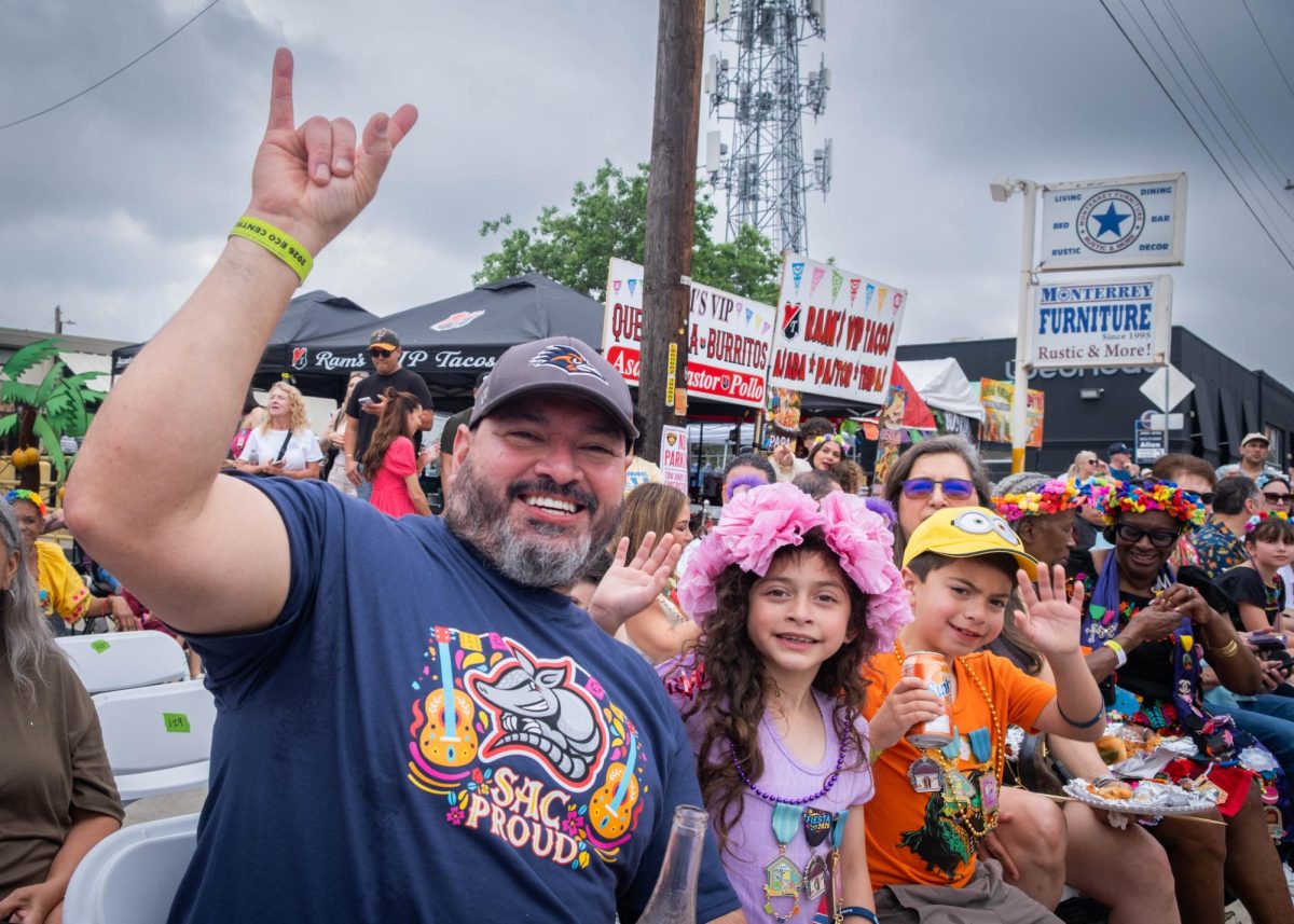 A group of festivalgoers pose for a photo during the Battle of Flowers Parade on Friday.