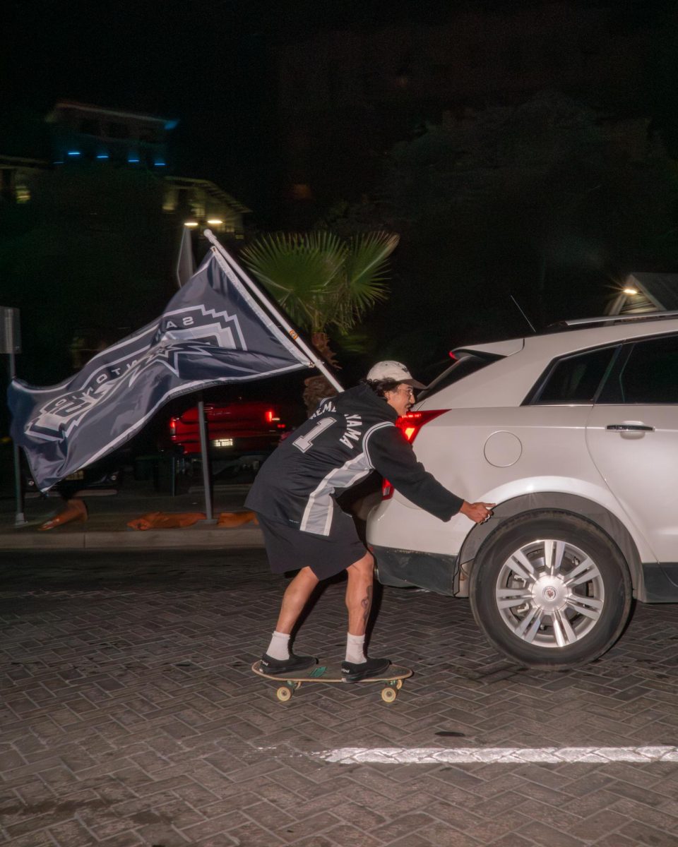 A Spurs fan skitches on a car after their victory. 