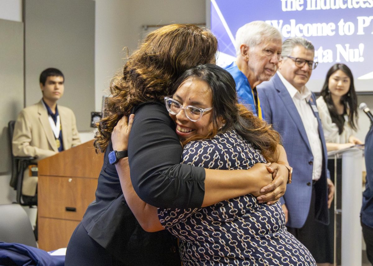 Student hugs Rayshunda Dawson, the chapter’s president, at the Phi Theta Kappa Induction Ceremony on Friday, April 17, in Room 218 of the Nursing Allied Health Center. 