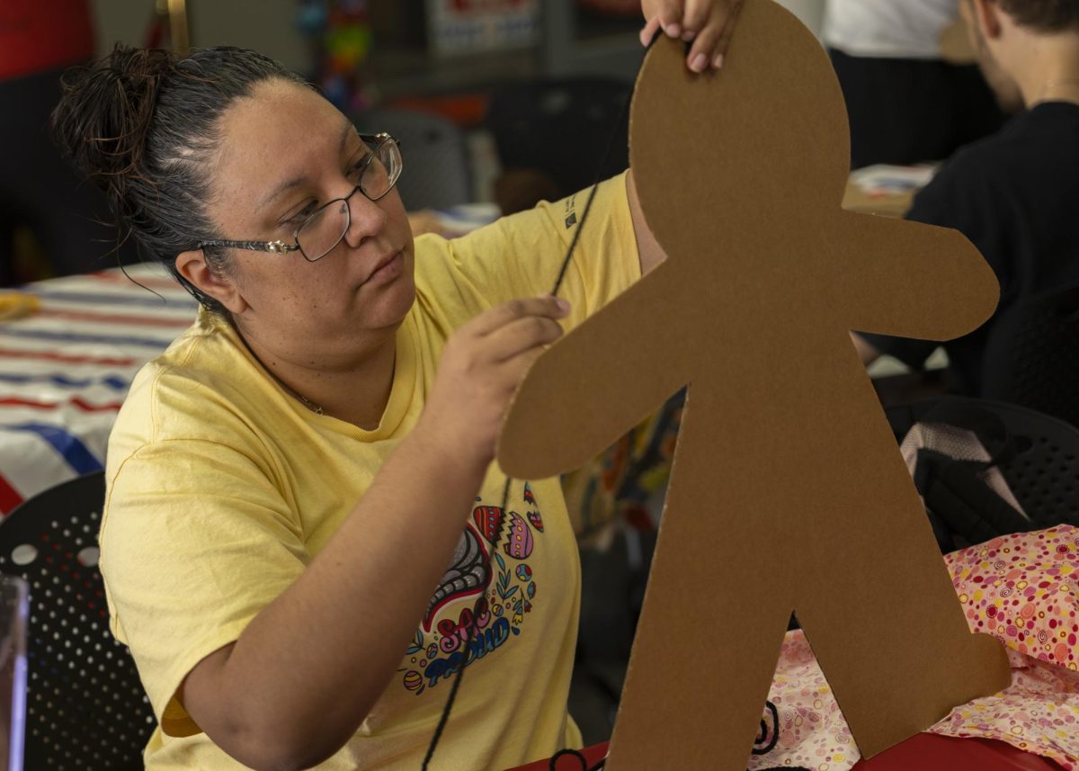 Melissa Compacts, Administrative Assistant works on her cardboard kid during CardBoard Kids at the Student Loftin Center. April 7. 