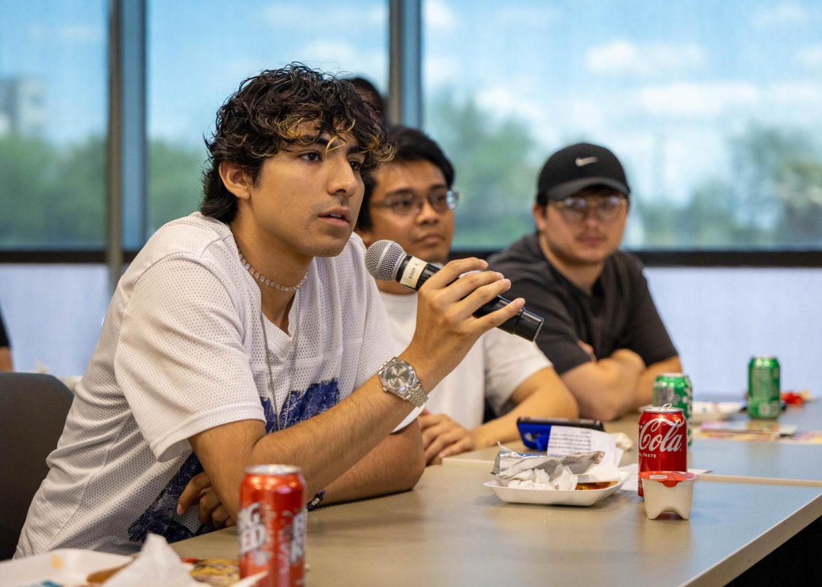 Ian Garcia, a music business major, asks Dr. Solis a question at the Pizza with the President event on Wednesday.