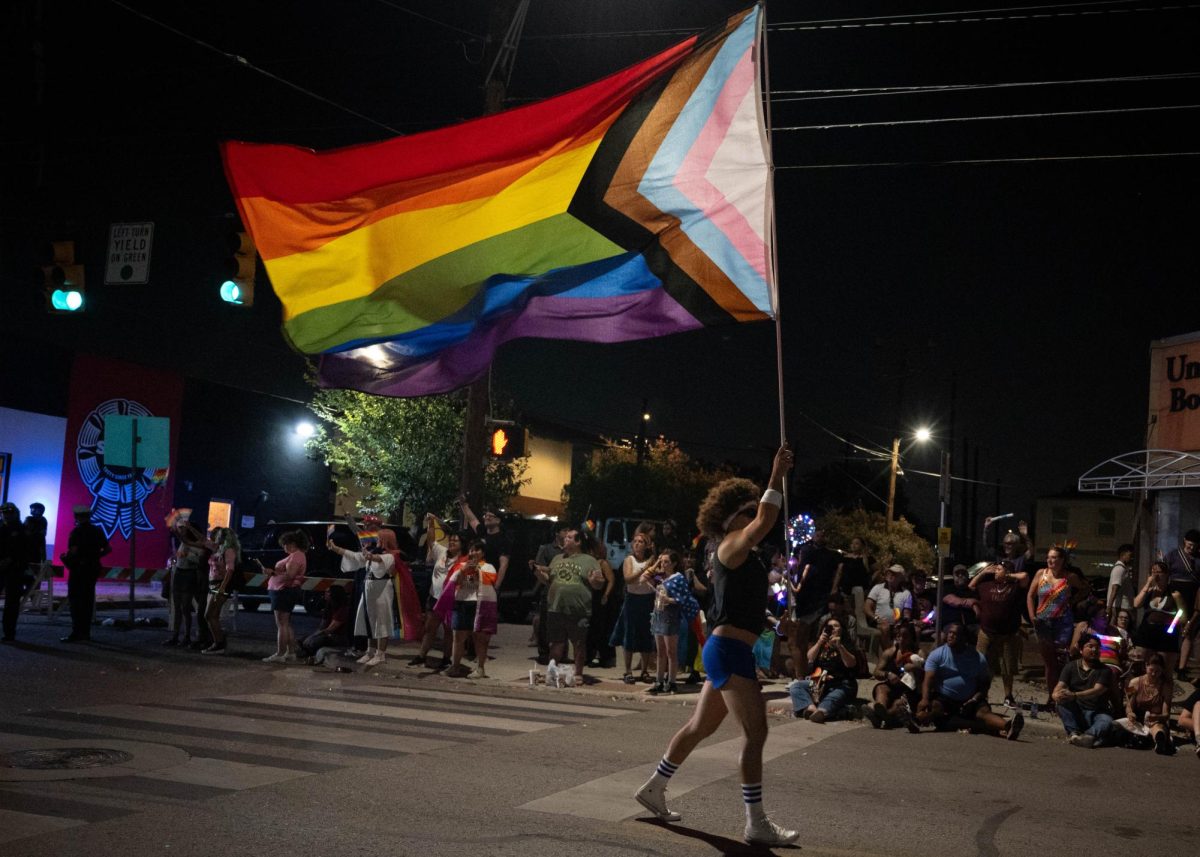 A marcher waves a large progress Pride flag at the San Antonio 2026 Pride parade on North Main Ave, June 27.